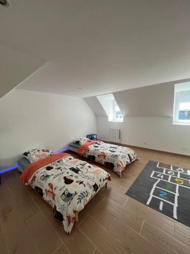 une chambre avec deux lits et un tapis dans l'établissement Viaduc et jeux, l'escapade idéale, à Morlaix
