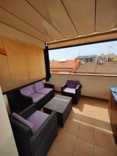 a balcony with couches and a view of a city at Hostal Manel in Pineda de Mar