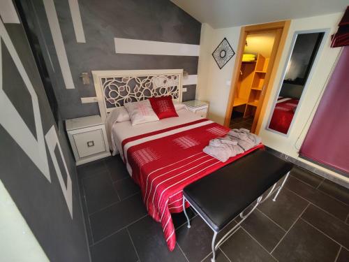 a small bedroom with a bed with a red blanket at Hostal Manel in Pineda de Mar