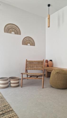 a room with a bench and a table and some vases at RASTONI VILLAS BY AEGEAN HOUSES in Psalidi
