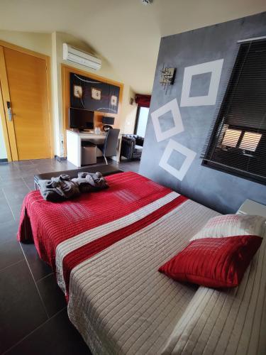 a bedroom with a large bed with a red blanket at Hostal Manel in Pineda de Mar