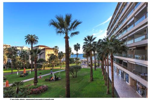 un palmier dans un parc à côté d'un bâtiment dans l'établissement REF 761 - Cannes Croisette - Sea view apartment for rent, à Cannes