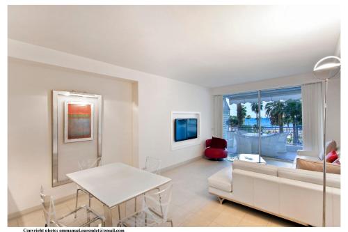 un salon avec un canapé blanc et une table dans l'établissement REF 761 - Cannes Croisette - Sea view apartment for rent, à Cannes
