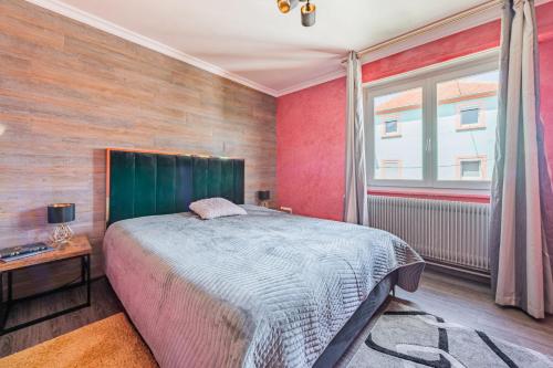 - une chambre avec un grand lit et une fenêtre dans l'établissement L'Adeline - Charmant appartement, à Lingolsheim