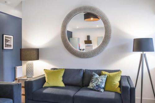 a living room with a blue couch and a mirror at The Woodside Apartments in Doune