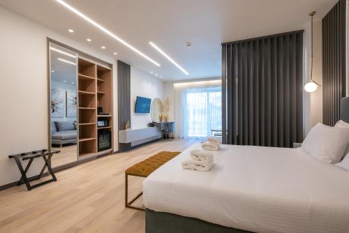 a bedroom with a large white bed and a living room at GRAND PATELLI in Myrina