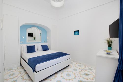 - une chambre avec un lit doté d'une tête de lit bleue dans l'établissement Estate4home - Casa Darly, à Positano