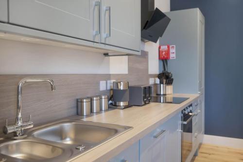 a kitchen with a sink and a counter top at The Woodside Apartments in Doune