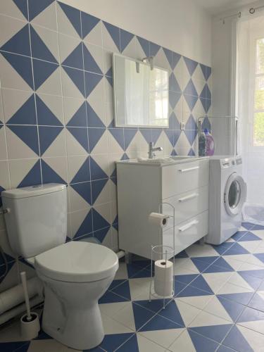 La salle de bains est pourvue de toilettes et de carrelage bleu et blanc. dans l'établissement Viaduc et jeux, l'escapade idéale, à Morlaix