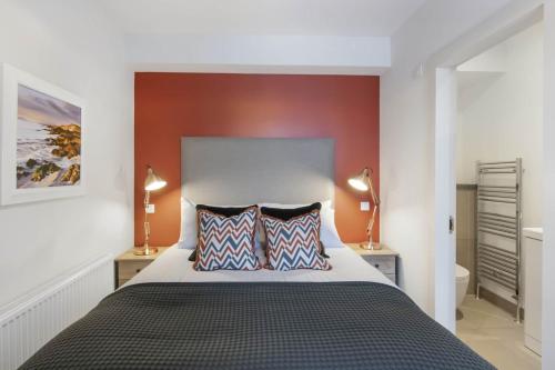 a bedroom with a large bed with two pillows at The Woodside Apartments in Doune