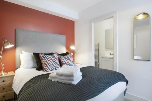 a bedroom with a bed with towels on it at The Woodside Apartments in Doune
