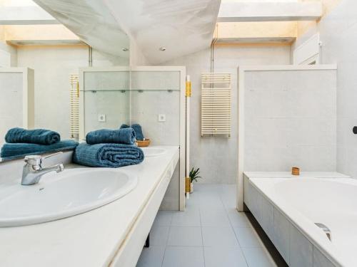 een witte badkamer met 2 wastafels en een bad bij Villa Alella Panoramic Views in Alella