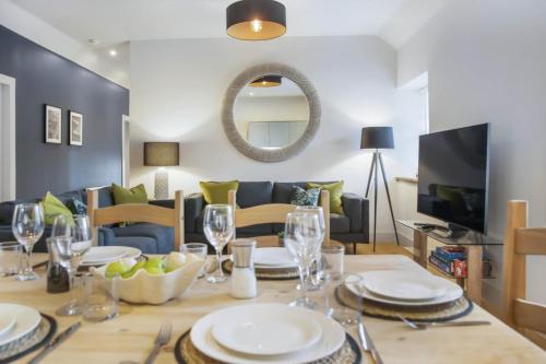 a dining room with a table with plates and wine glasses at The Woodside Apartments in Doune