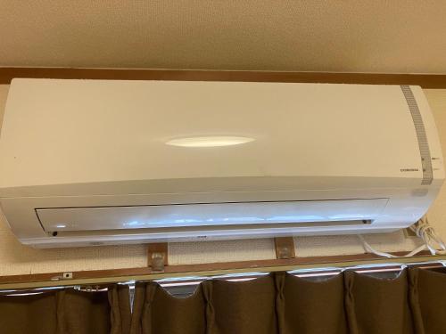 a flat screen tv sitting on top of a shelf at Casa Viento Stay Inn in Hiroshima