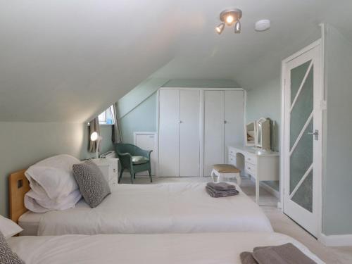 a bedroom with two beds and a desk with a tv at Awelfryn in Holyhead