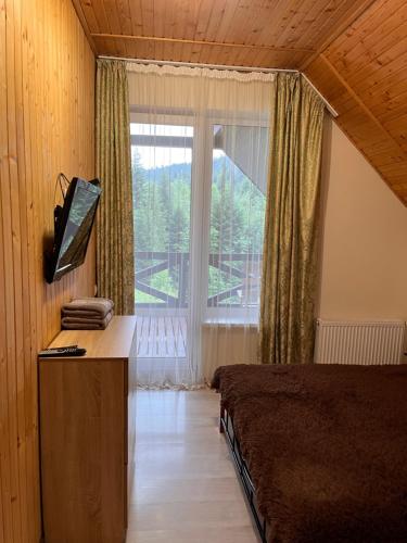 スキュネイザにあるBelvedere-Karpatyのベッドルーム1室(ベッド1台、大きな窓付)
