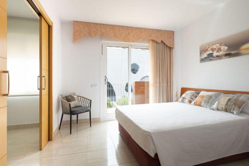a bedroom with a bed and a window and a chair at Centric apartment gran via fira montjuic in Hospitalet de Llobregat