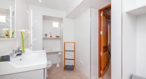 Un baño blanco con lavabo e inodoro. en Ses Salines, 4409-56 Mallorca - Ses Puntes-, en Ses Salines