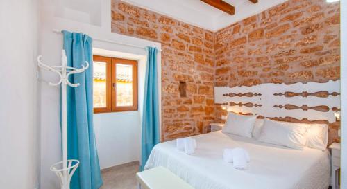 Un dormitorio con una cama y una pared de ladrillo. en Ses Salines, 4409-56 Mallorca - Ses Puntes-, en Ses Salines