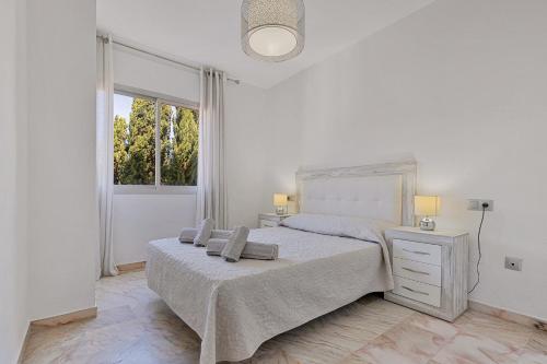 ein weißes Schlafzimmer mit einem Bett und einem Fenster in der Unterkunft Solana Hispanidad in Fuengirola