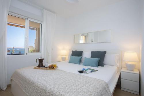 Un dormitorio blanco con una gran cama blanca y una ventana en SingularStays El Puig Beach II, en Las Canteras