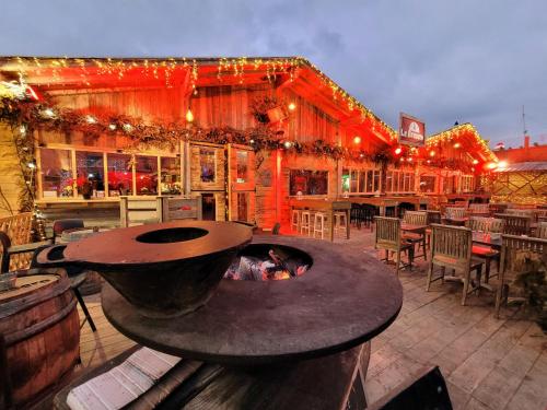 une terrasse avec un foyer extérieur en face d'un restaurant dans l'établissement La Paillotte entre Lac Marin et Mer, au Barcarès