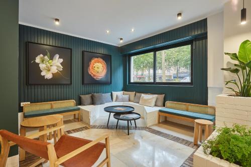 Una sala de estar con un sofá, una mesa y sillas. en Hôtel Beauquartier Montmartre, en París