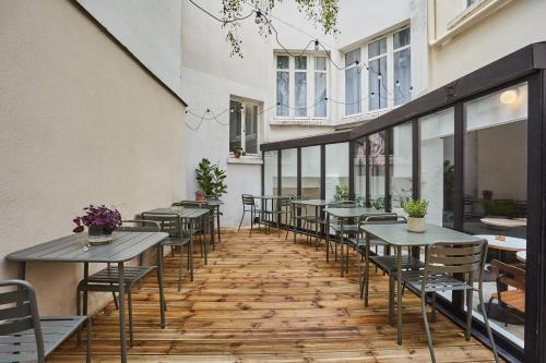 une rangée de tables et de chaises sur une terrasse dans l'établissement Hôtel Beauquartier Montmartre, à Paris