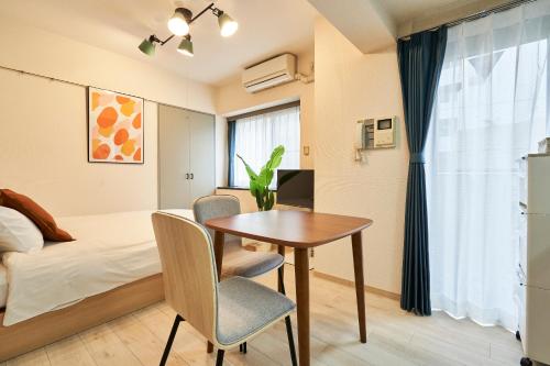 Schlafzimmer mit einem Schreibtisch, einem Bett und einem Tisch in der Unterkunft WINBELL DUET Ebisu5 in Tokio