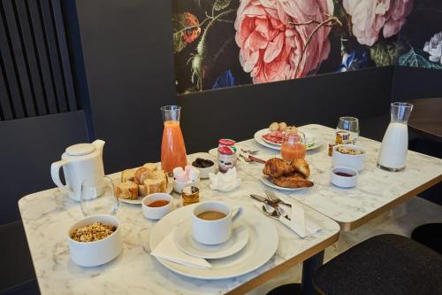 una mesa con desayuno y café. en Hôtel Beauquartier Montmartre, en París