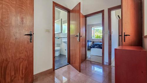 ein Badezimmer mit Holztüren und einem Spiegel in der Unterkunft Casa Elza in Dajla