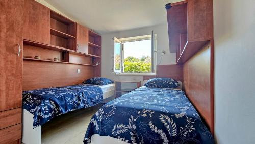 ein Schlafzimmer mit zwei Betten und einem Fenster in der Unterkunft Casa Elza in Dajla