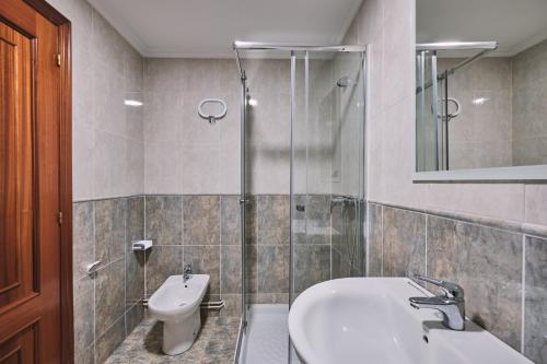 a bathroom with a shower and a sink and a toilet at Peregrina Pensión 5 in O Pedrouzo