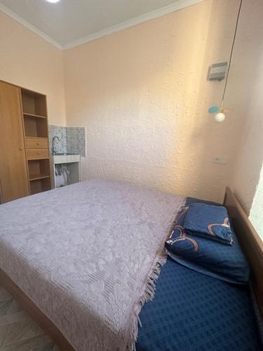 a bedroom with a large bed with a blue carpet at Sweet Home Hostel in Bishkek