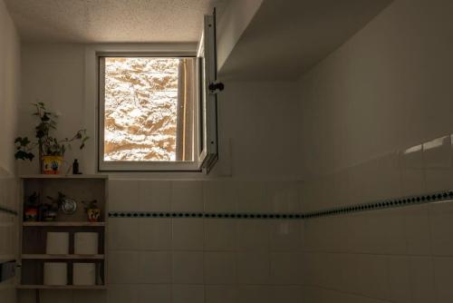 a window in a bathroom with a tub and a shower at Casanova94 Guesthouse in Piraeus