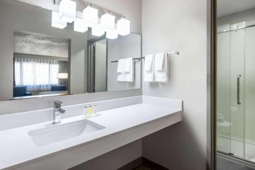 a bathroom with a sink and a mirror at Days Inn by Wyndham Sioux Falls Airport in Sioux Falls