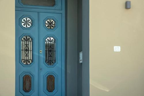 a blue door with two windows on it at Casanova94 Guesthouse in Piraeus