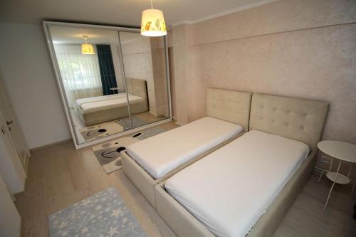 een kleine kamer met een bed en een spiegel bij Luxuriously flat fully equipped quality appliances in Tulcea