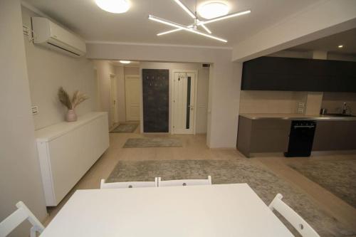 a kitchen with a white table and a ceiling fan at Luxuriously flat fully equipped quality appliances in Tulcea
