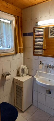 a small bathroom with a sink and a mirror at Ferienhaus Fernblick in Fraxern