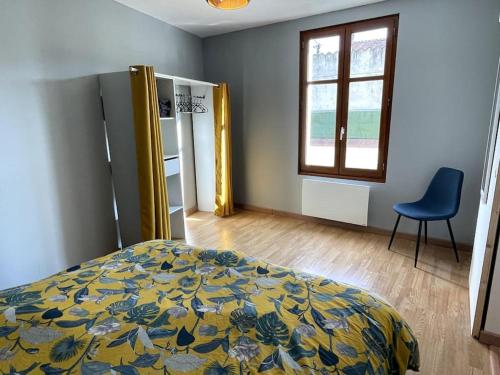 a bedroom with a bed and a chair and a window at La Cartelée in Saint-Amand-Montrond