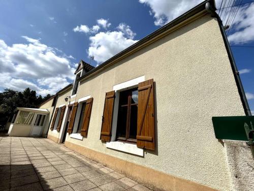 a building with wooden doors on the side of it at La Cartelée in Saint-Amand-Montrond