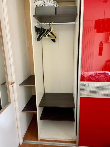 un dressing avec quelques étagères et quelques chaussures dans l'établissement Chambres privées avec piscine partagées et cuisine partagée à 20 minutes de Paris et 40 minutes de disneyland, à Fontenay-sous-Bois