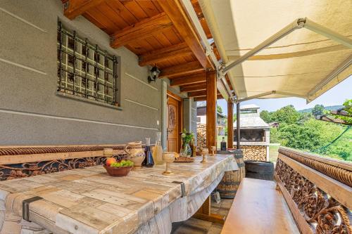 un patio al aire libre con una mesa de madera y una sombrilla en Vineyard Cottage Stepan - Happy Rentals, en Črnomelj