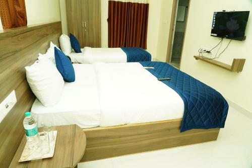 a hotel room with a large bed and a table at NJK Residency in Yercaud