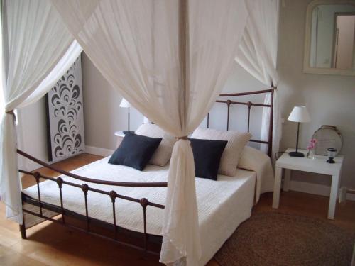 - une chambre avec un lit à baldaquin et des oreillers bleus dans l'établissement Soleil et piscine au calme d'Avignon, sur l'ile de la BARTHELASSE, à Avignon