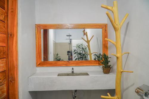 a bathroom with a sink with a mirror at Hillside bali in Kubupenlokan
