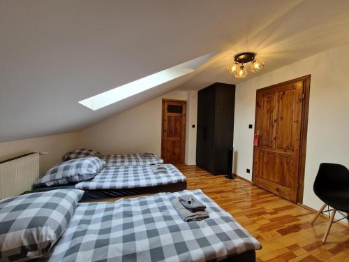 two beds in a room with a ceiling at Gościniec Błogocice in Cieszyn