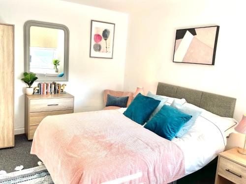 a bedroom with a large bed with blue pillows at Northumberland Boutique Guest House #5 in Coventry