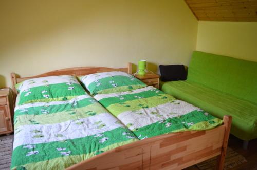 a bedroom with a bed with a green and white comforter at Privat Lubika in Trstené